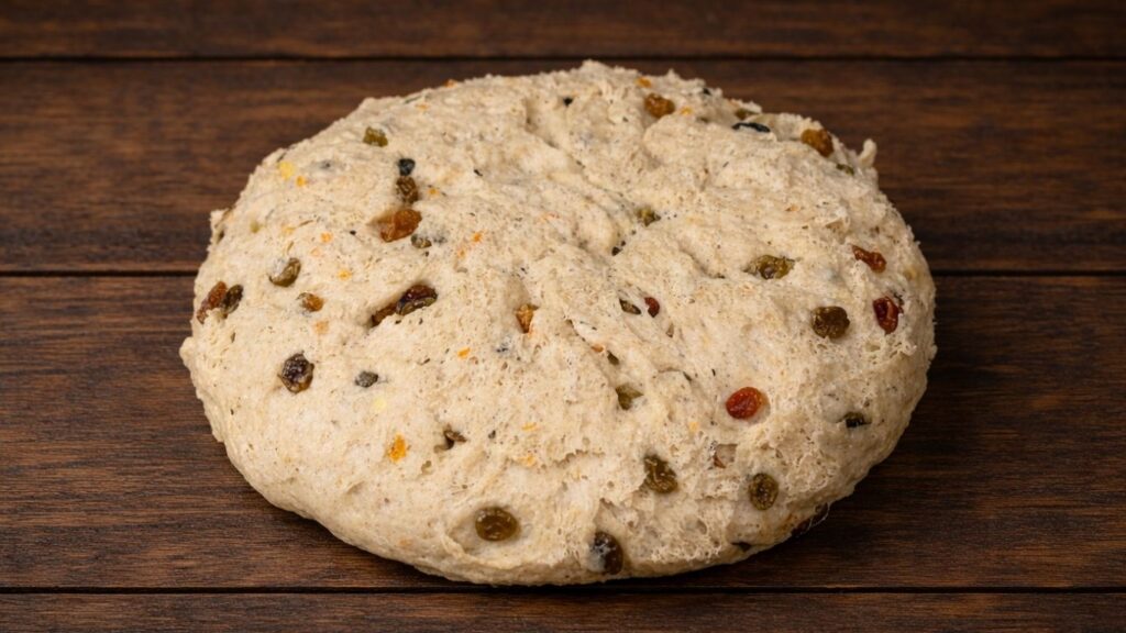 Soft and fluffy Hot Cross Buns – risen dough transferred from the bowl onto a lightly floured work surface, soft, airy and ready for shaping into buns.