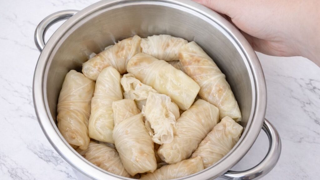 Rolled sarma arranged inside a pot, neatly packed stuffed sour cabbage rolls ready for cooking