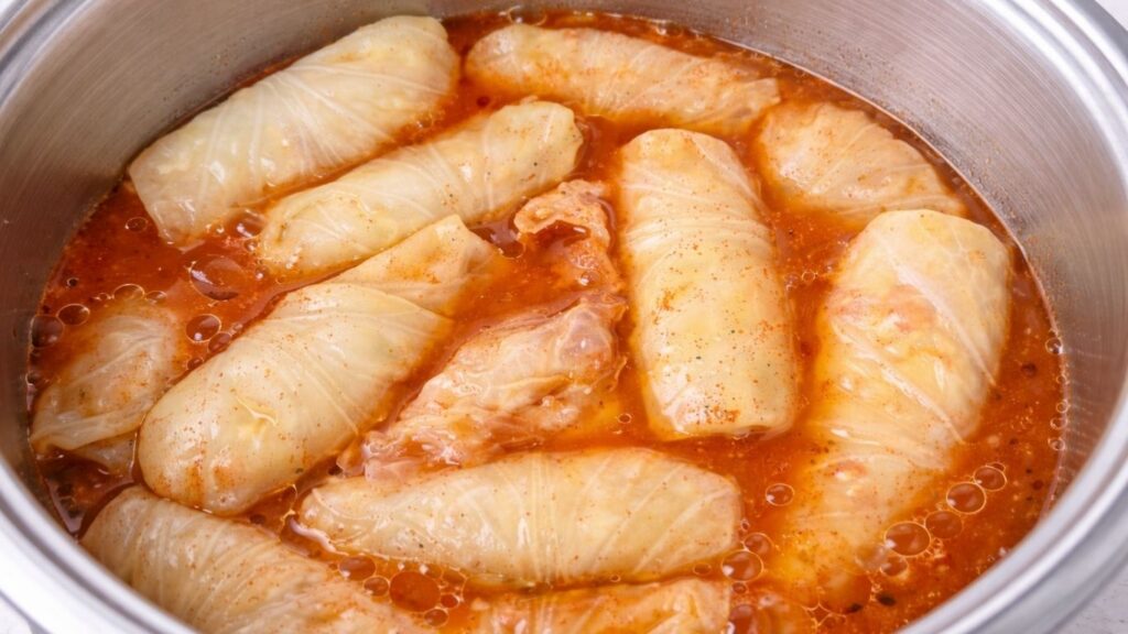 Sarma arranged in a pot and covered with seasoned water, ready to cook as traditional stuffed sour cabbage rolls