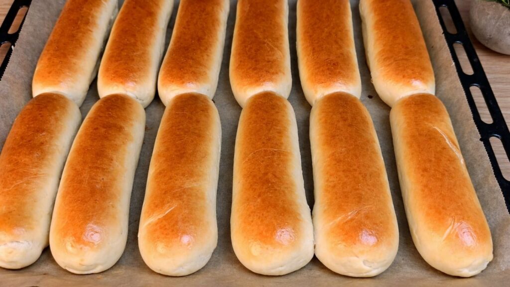 Freshly baked homemade hot dog buns taken out of the oven.