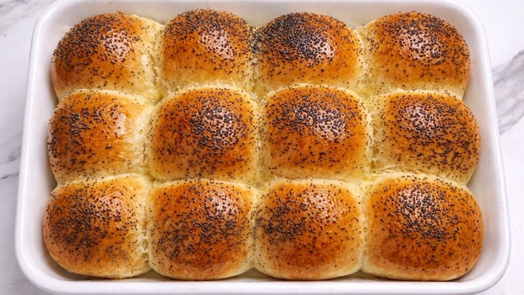 freshly baked golden dinner rolls in a baking tray