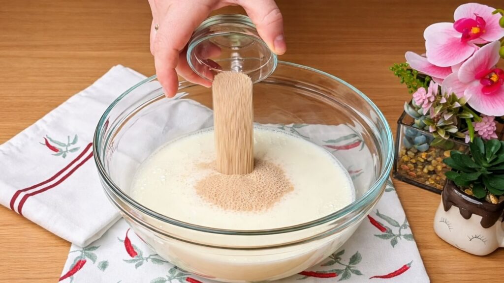 Pouring instant yeast into warm milk to activate the yeast for the Easy Milk Buns Recipe.