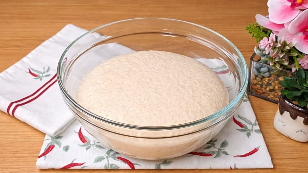 Activated yeast mixture in warm milk with a foamy surface, ready to prepare the dough for the Easy Milk Buns Recipe.