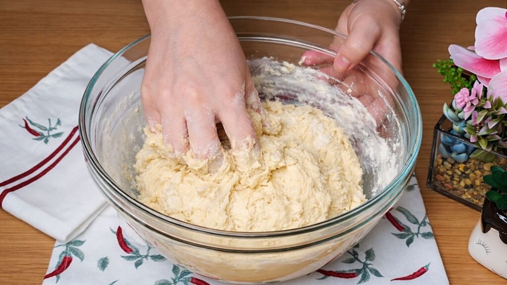 Mixing the dough by hand in a bowl until the ingredients come together to form a soft dough for the Easy Milk Buns Recipe.
