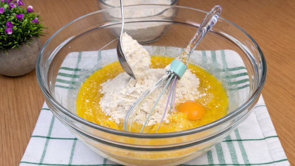 adding part of the flour to the yeast mixture while preparing the dough for blueberry lemon rolls
