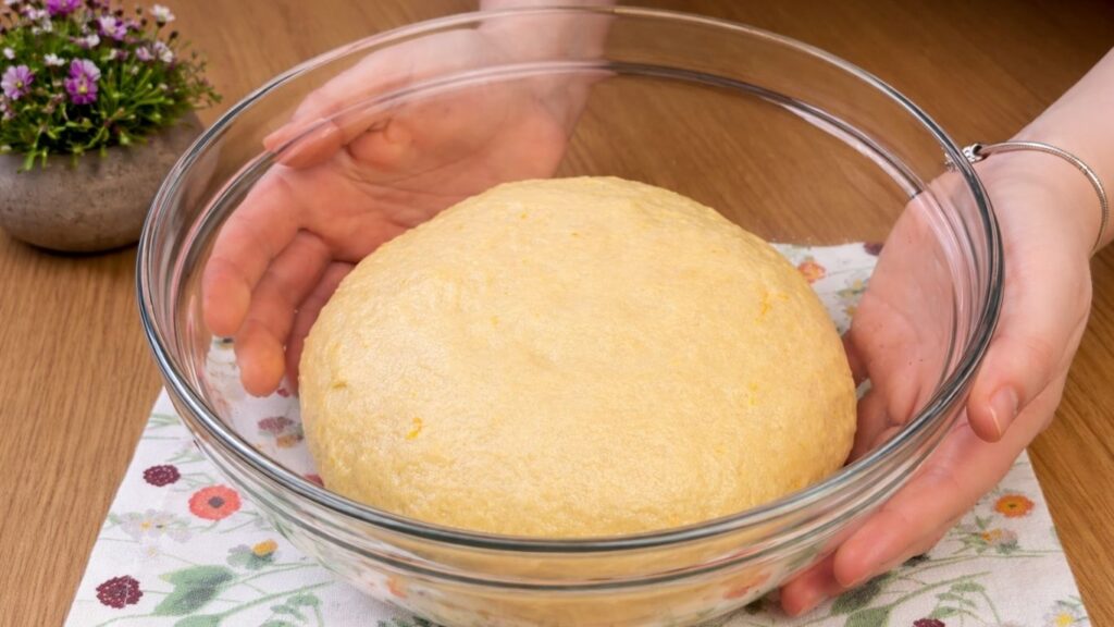 risen dough doubled in size in a bowl ready for shaping blueberry lemon rolls
