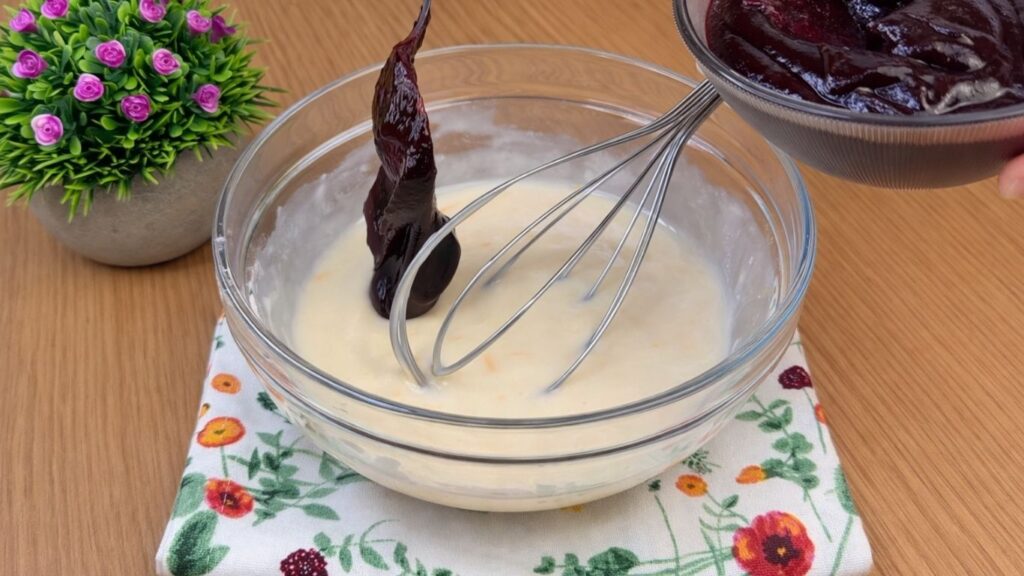 adding a spoonful of blueberry jam to the cream cheese frosting for blueberry lemon rolls