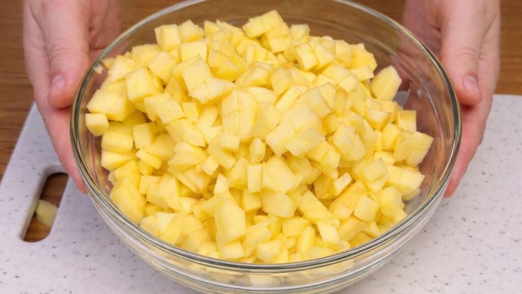Bowl filled with diced apples prepared for the apple cinnamon roll filling.