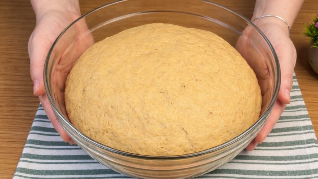 Risen apple cinnamon roll dough in a bowl after resting, doubled in size and ready to shape.