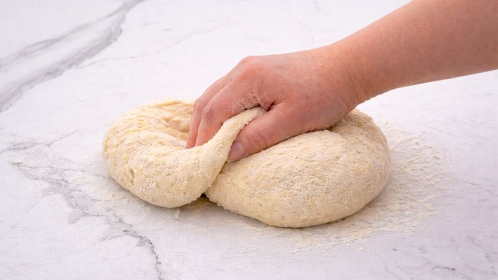 mixing dough by hand in a bowl to prepare potato borek dough