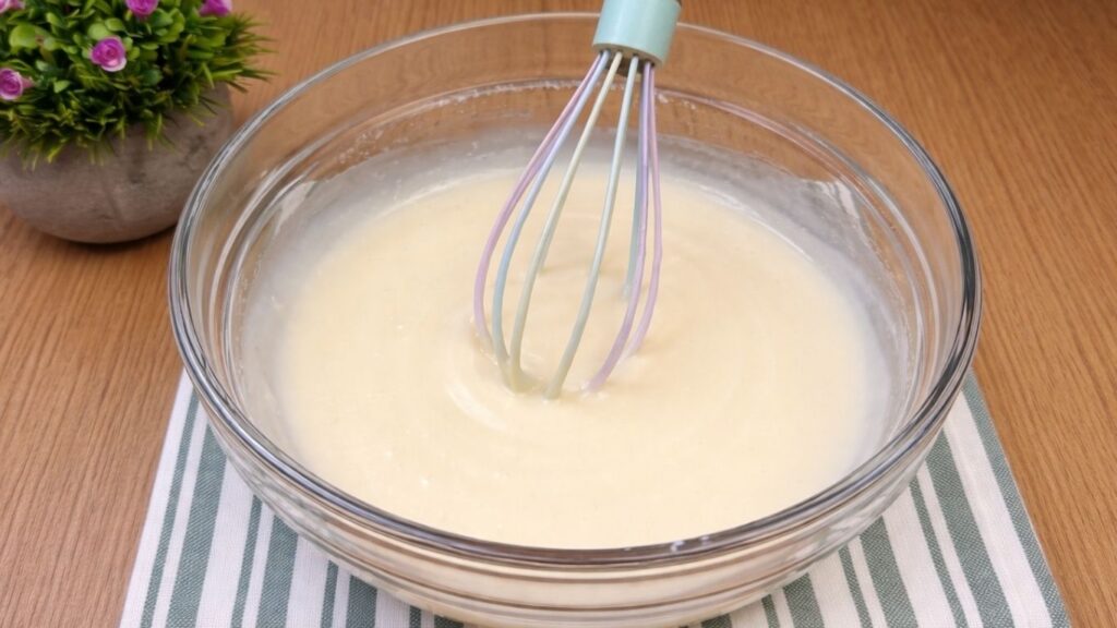 Creamy whipped cream cheese glaze prepared for topping apple cinnamon rolls.