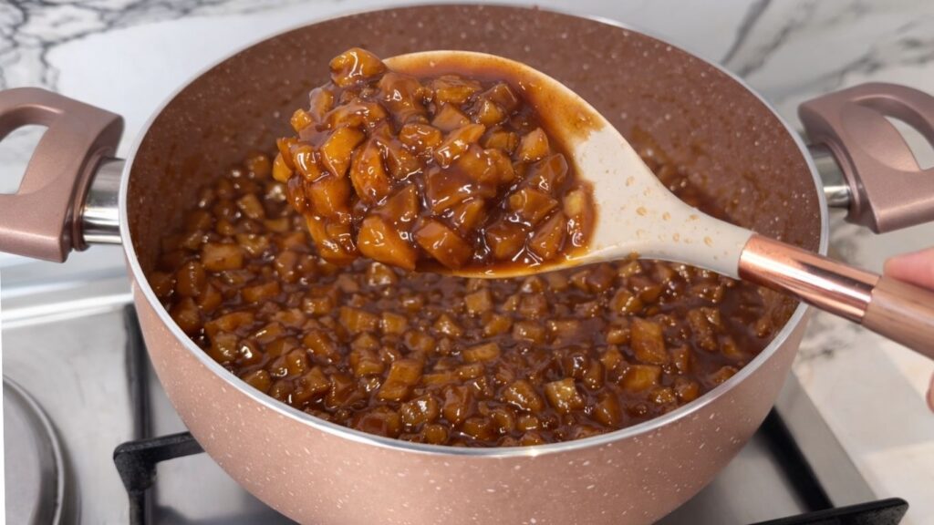 Cooked apple cinnamon filling in a saucepan with soft apples ready to use for apple cinnamon rolls.