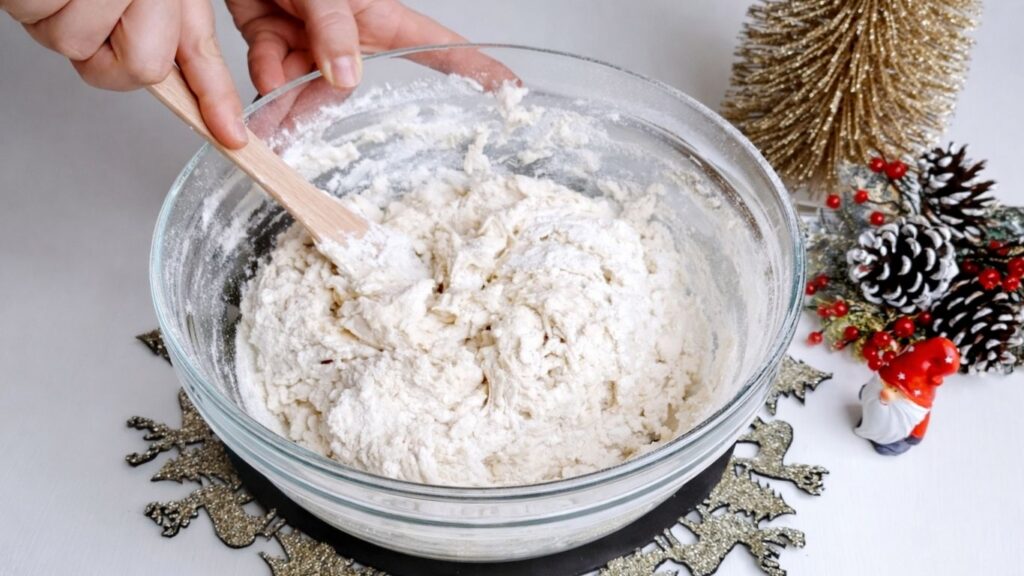Preparing homemade baguette dough with wooden spoon