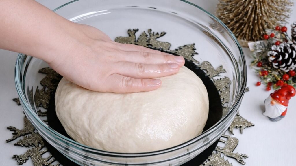 Fresh baguette dough resting in oiled bowl