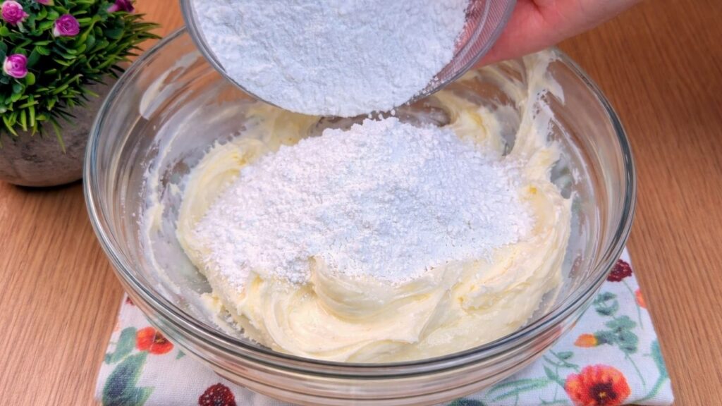 adding powdered sugar to cream cheese glaze mixture