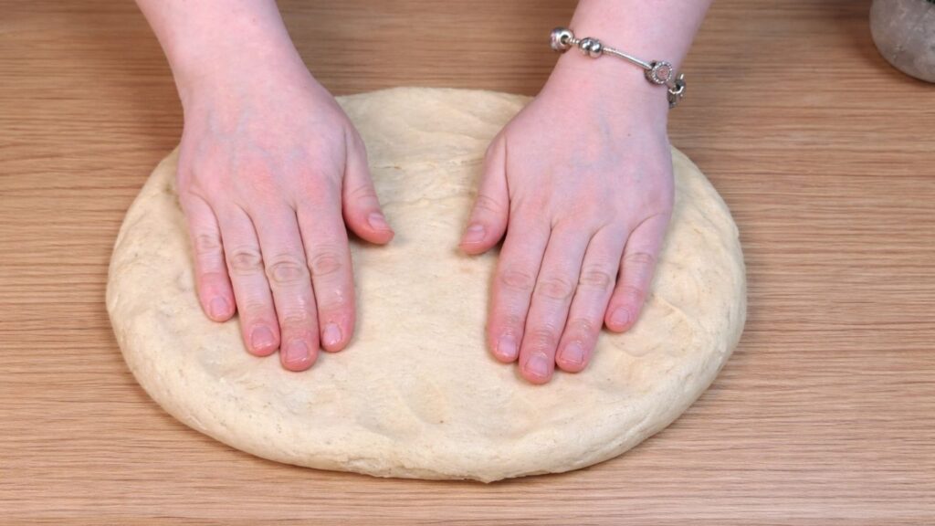stretching dough by hand for homemade cinnamon rolls