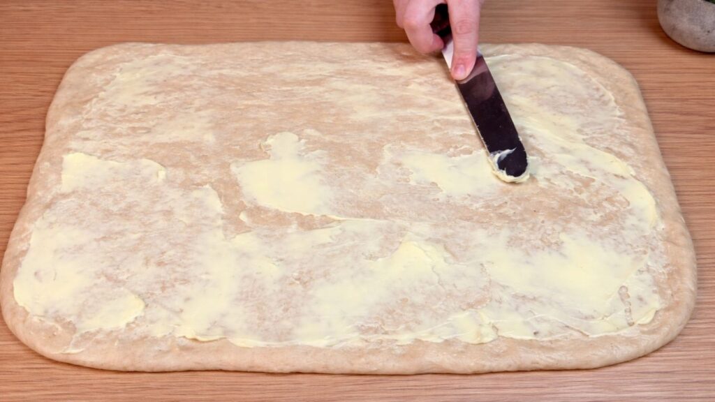 rolled out dough spread with softened butter for homemade cinnamon rolls