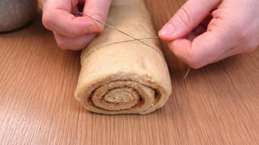 cutting cinnamon roll dough with thread for clean slices