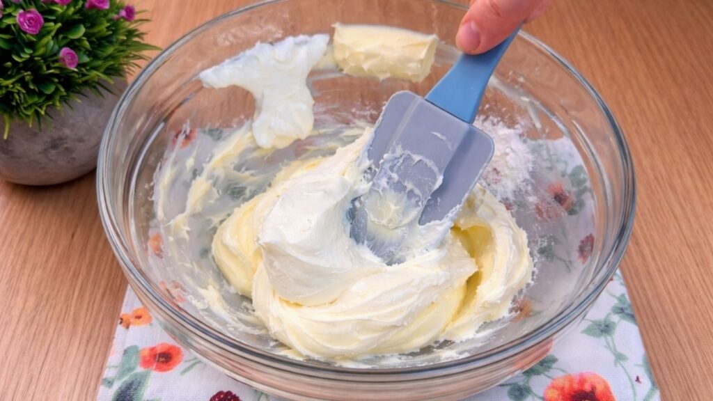 adding cream cheese to butter mixture for cream cheese glaze