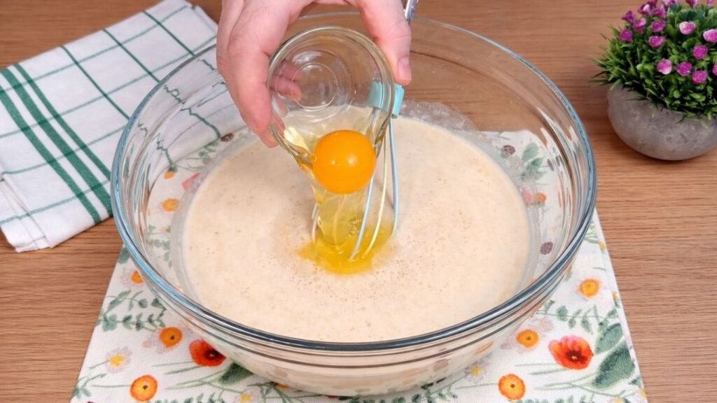 adding egg to activated yeast mixture for homemade cinnamon rolls dough