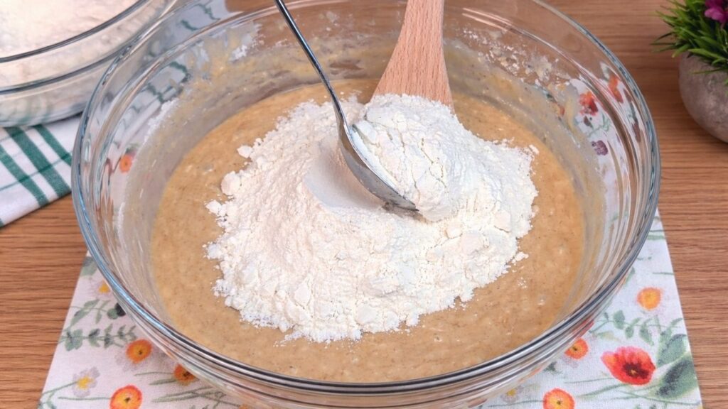 adding flour to the dough mixture for homemade cinnamon rolls