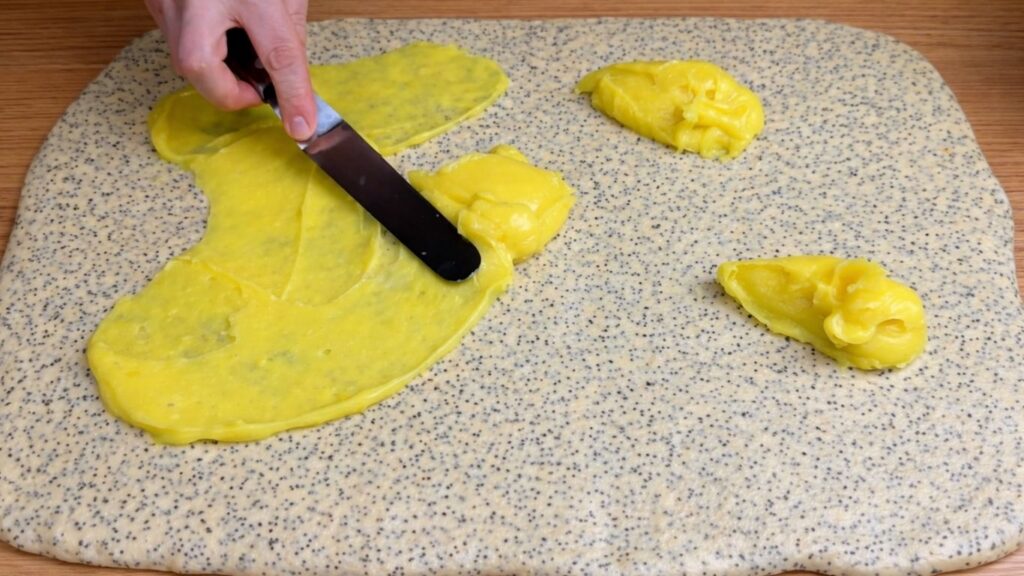 spreading lemon cream filling on dough