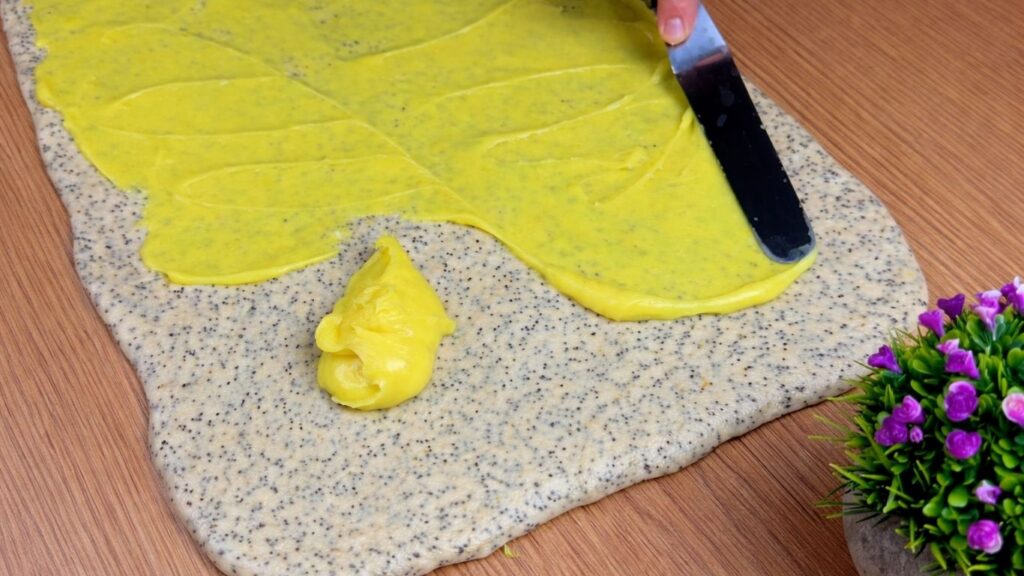 lemon cream evenly spread on sweet roll dough