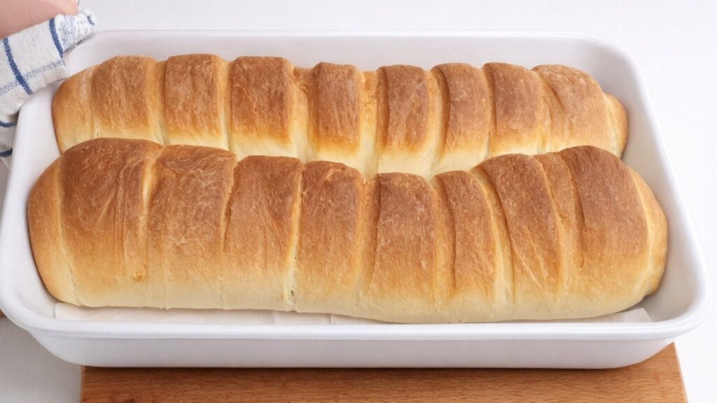 freshly baked milk bread loaf in ceramic baking dish