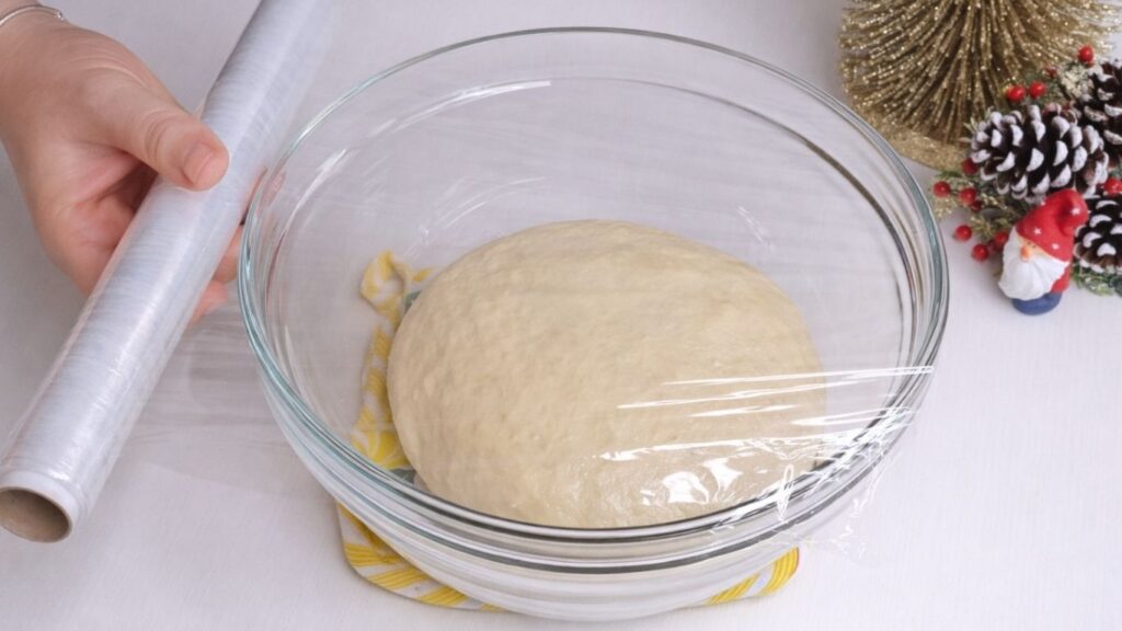 covering milk bread dough with plastic wrap before rising