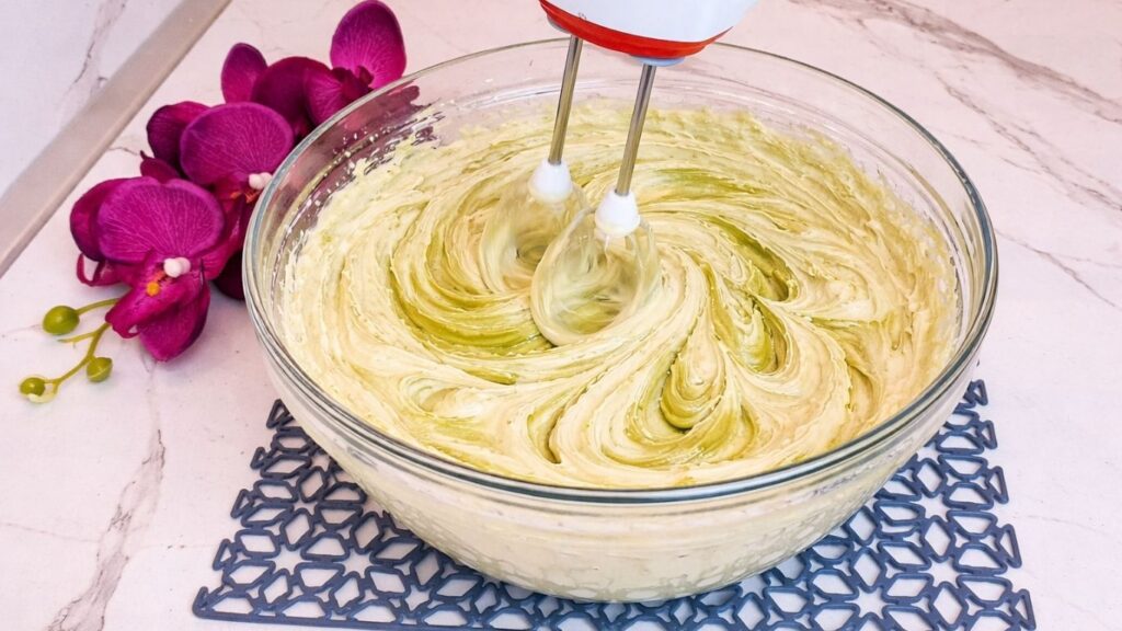 Mixing pistachio cream with vanilla cream using a mixer