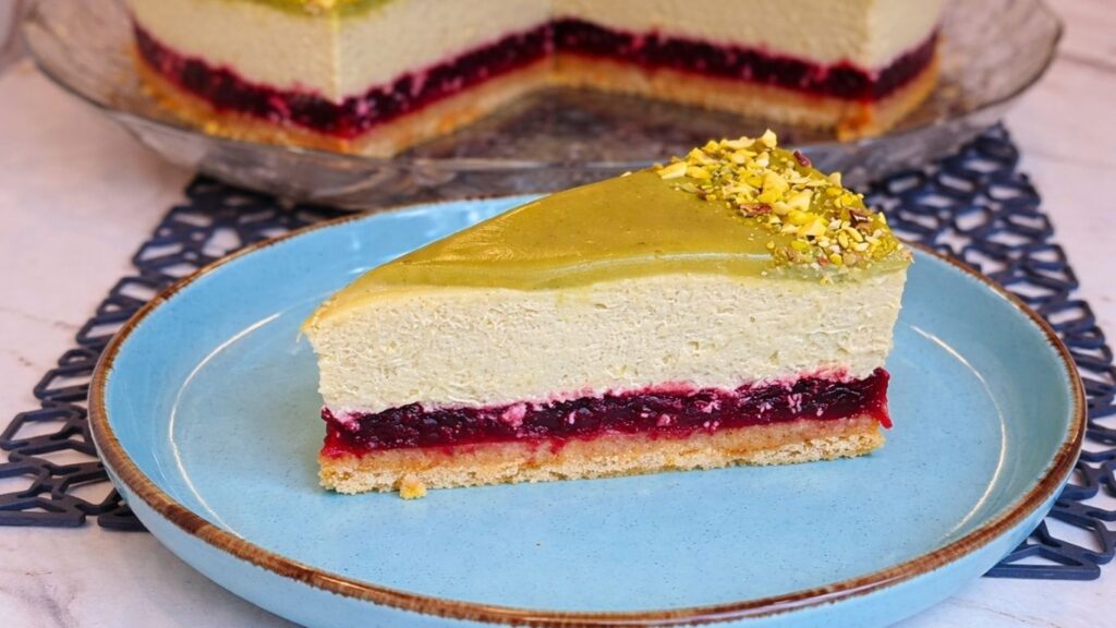 Slice of no bake pistachio cake with cherry layer on a fork