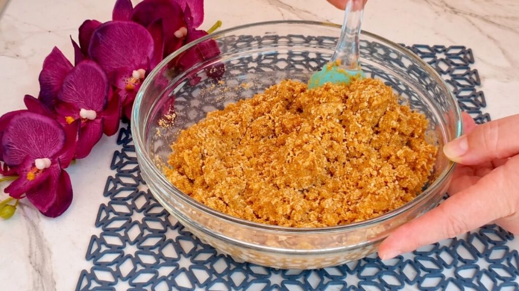 Mixing crushed cookies and melted butter for no bake cake crust