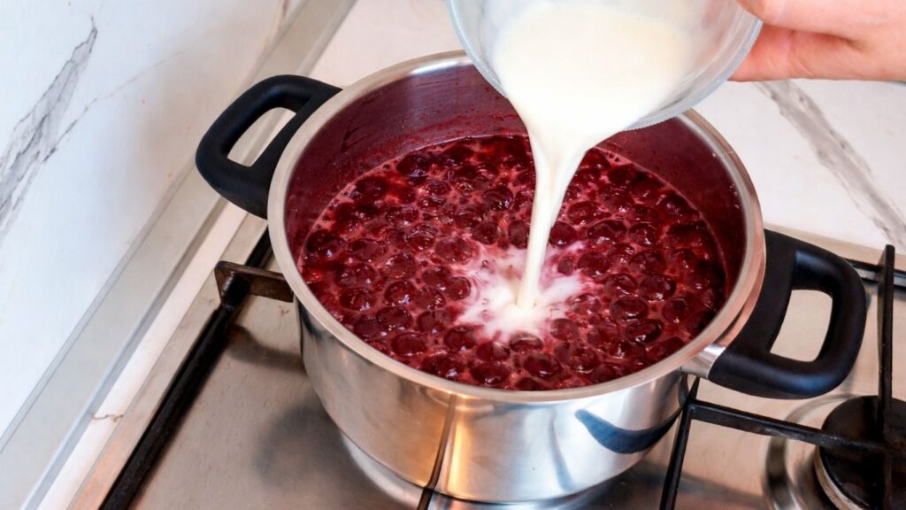 Adding cornstarch mixture to cherries to thicken cherry layer