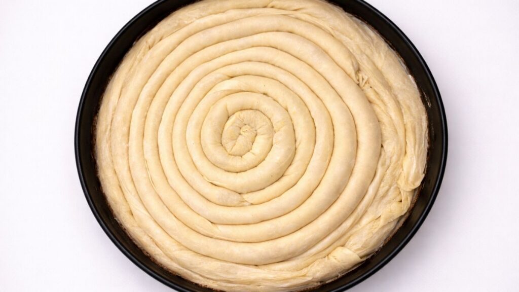 spiral potato borek arranged in a baking pan ready for baking
