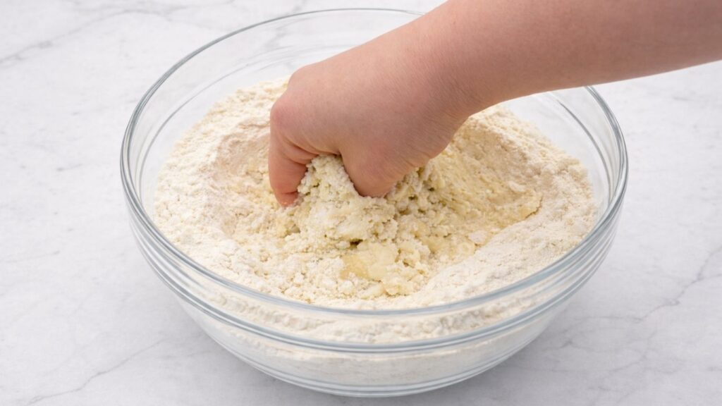 mixing dough by hand in a bowl to prepare potato borek dough