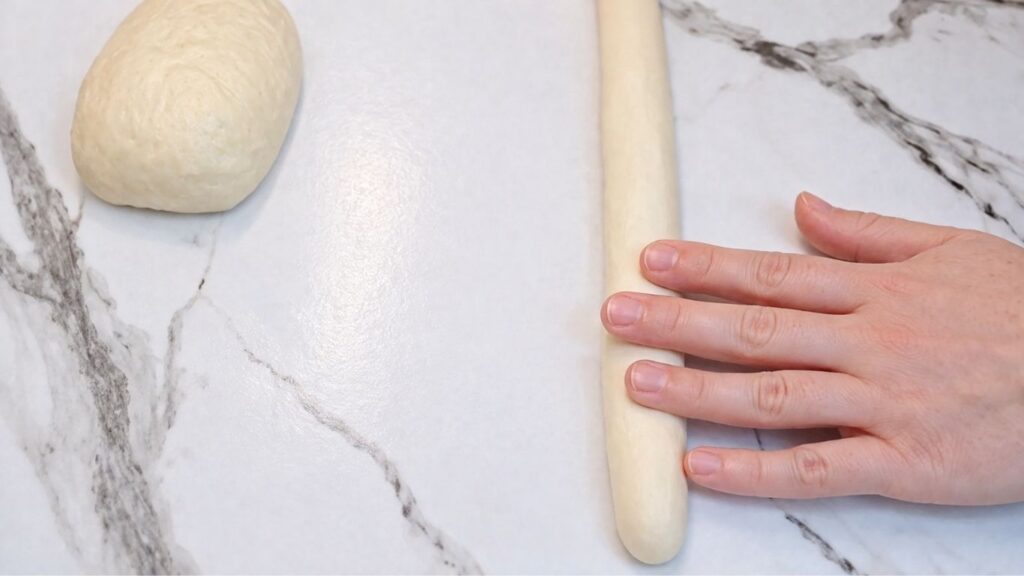 Shaping homemade pretzel dough into a classic pretzel shape by hand.