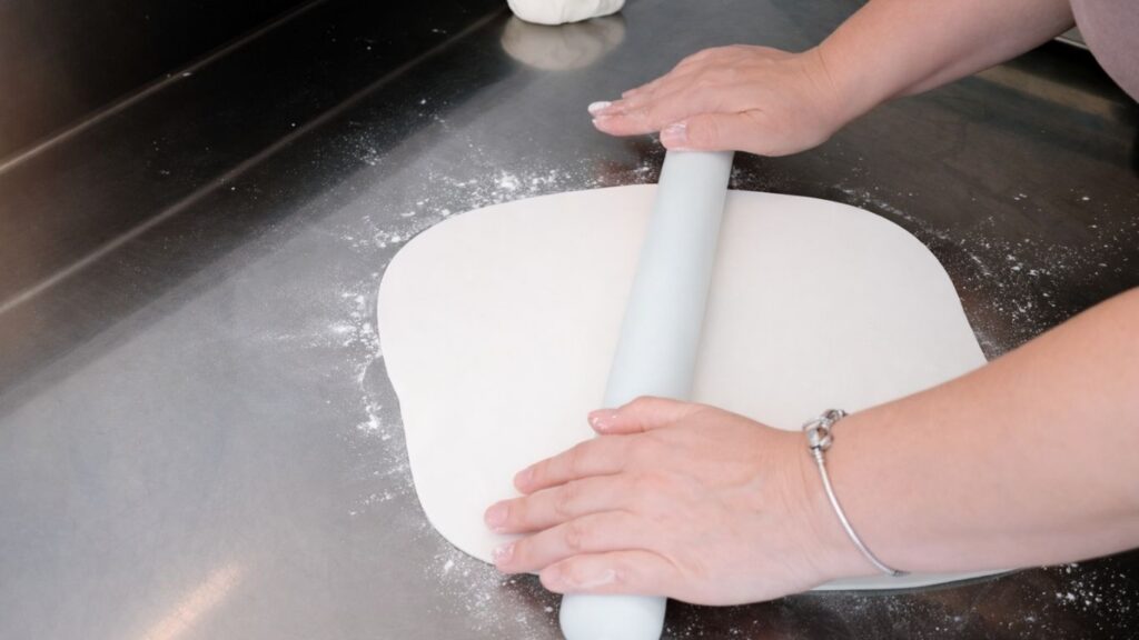 Rolling out fondant for a 3-tier wedding cake