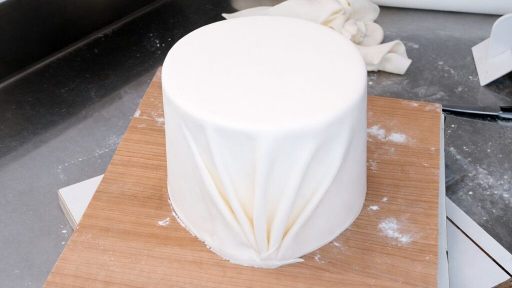 Covering a 3-tier wedding cake with fondant