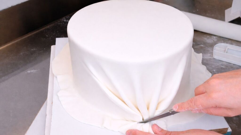 Covering a 3-tier wedding cake with fondant