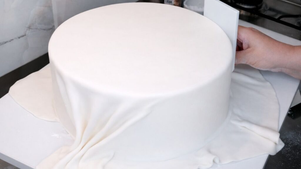 Covering a 3-tier wedding cake with fondant