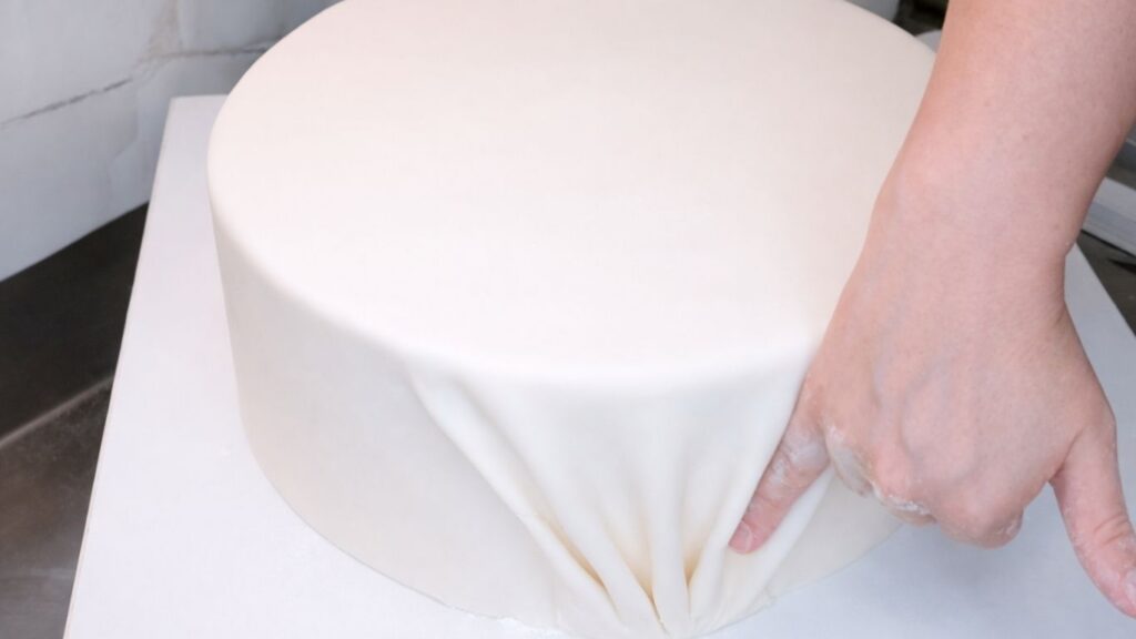 Covering a 3-tier wedding cake with fondant