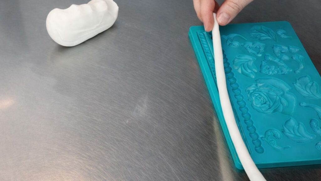 Making fondant pearls in a silicone mold for a 3-tier wedding cake