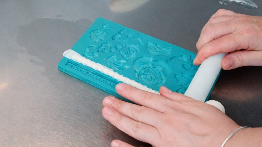 Making fondant pearls in a silicone mold for a 3-tier wedding cake