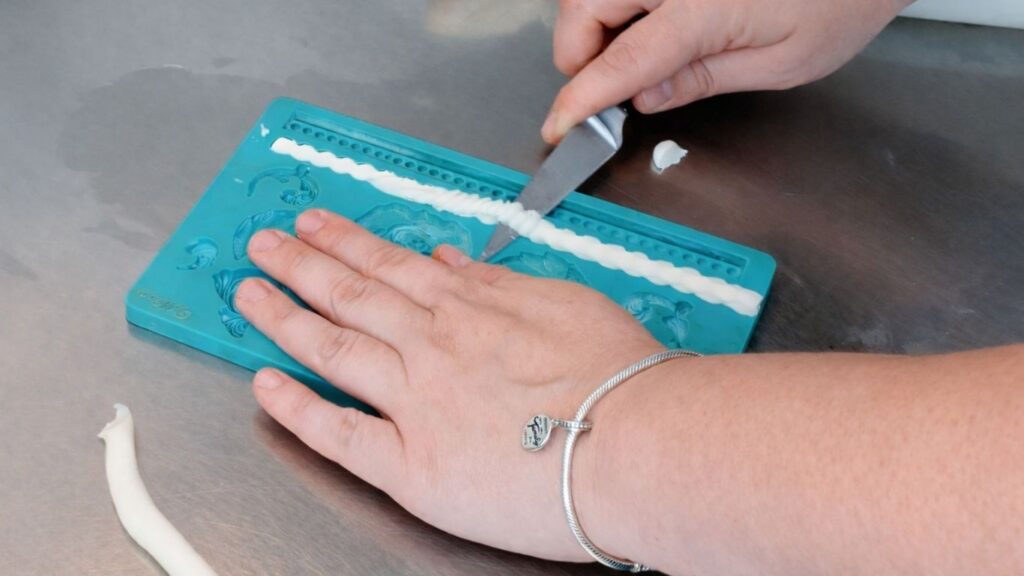 Making fondant pearls in a silicone mold for a 3-tier wedding cake