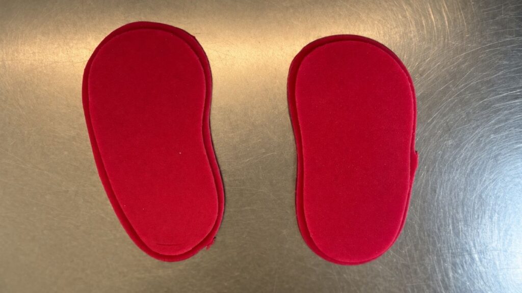 Pink fondant baby shoes sole and in-sole pieces attached together ready for assembling
