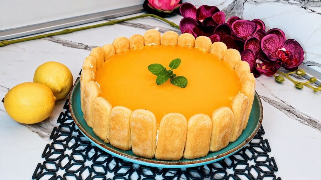 Finished no-bake lemon cake with ladyfingers, glossy lemon glaze, and fresh mint on top