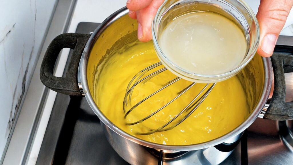 Adding lemon juice to the cooked cream filling for no-bake lemon cake