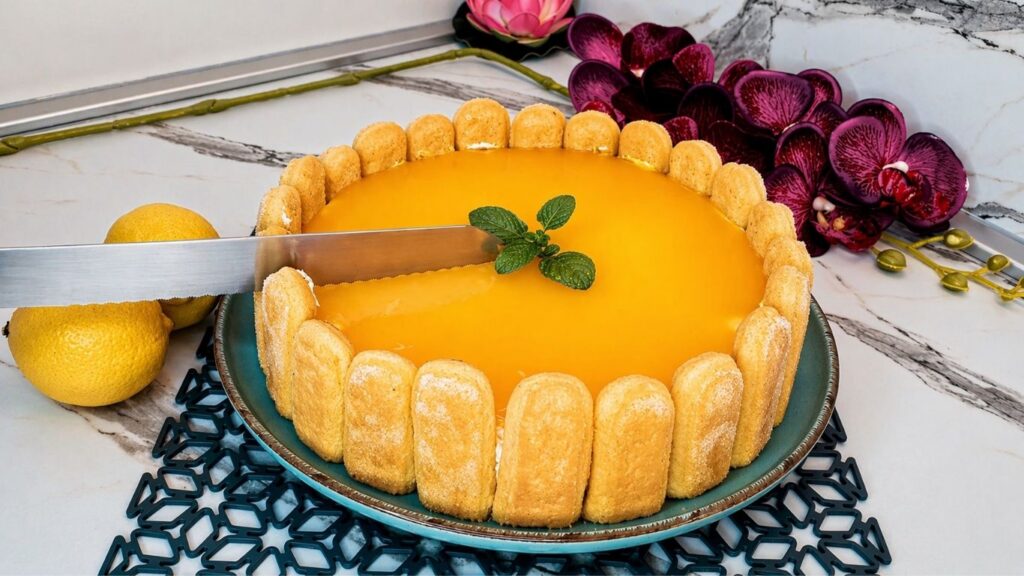 Finished no-bake lemon cake with ladyfingers, glossy lemon glaze, and fresh mint on top