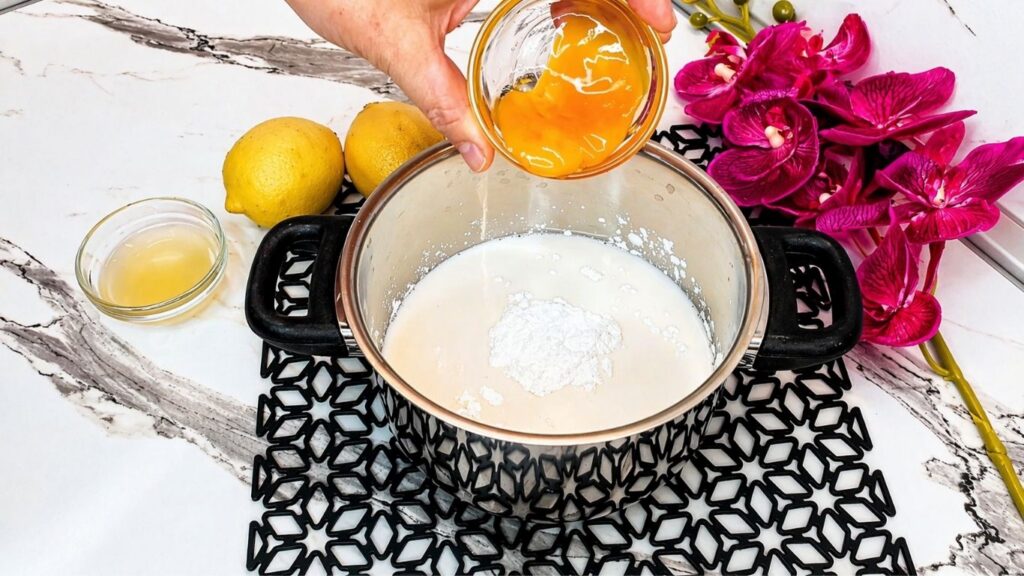 Adding egg yolk to milk for the cream filling of no-bake lemon cake