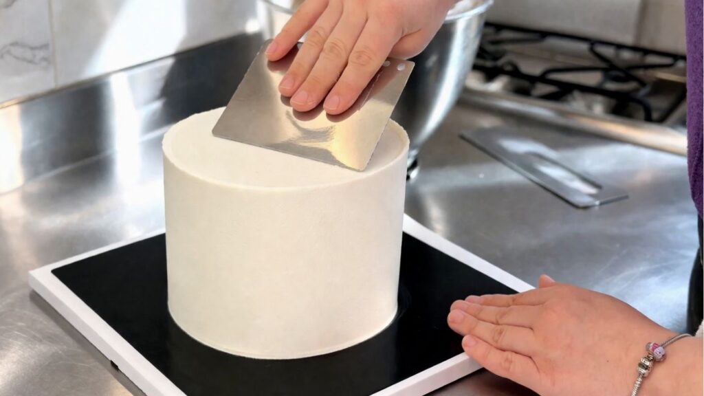 
Applying and smoothing buttercream on a two-tier 40th birthday cake before fondant decorating